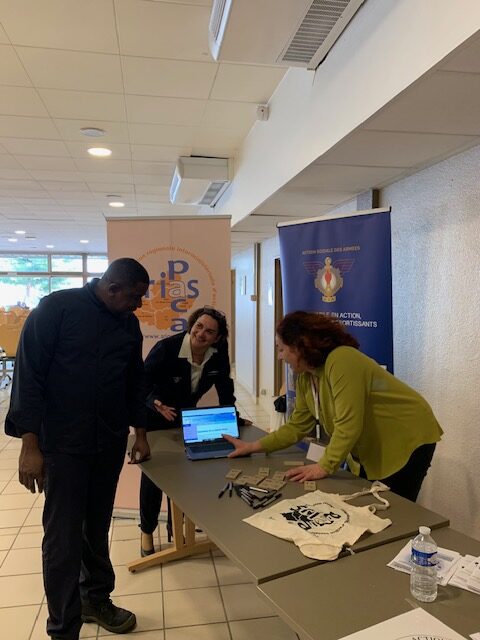 2 femmes et un homme autour du stand de la srias. En arrière plan le roll up de la SRIAS avec son logo et QRcode