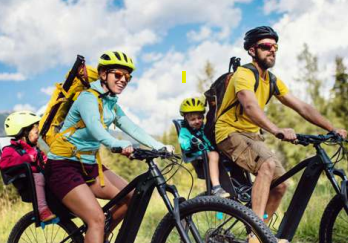 un père et une mère à vélo avec leurs 2 jeunes enfants derrière