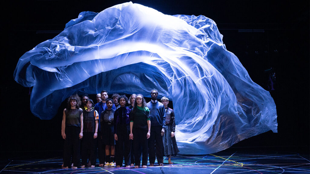 Groupe de chanteurs danseurs serrés debout devant comme un voile blanc