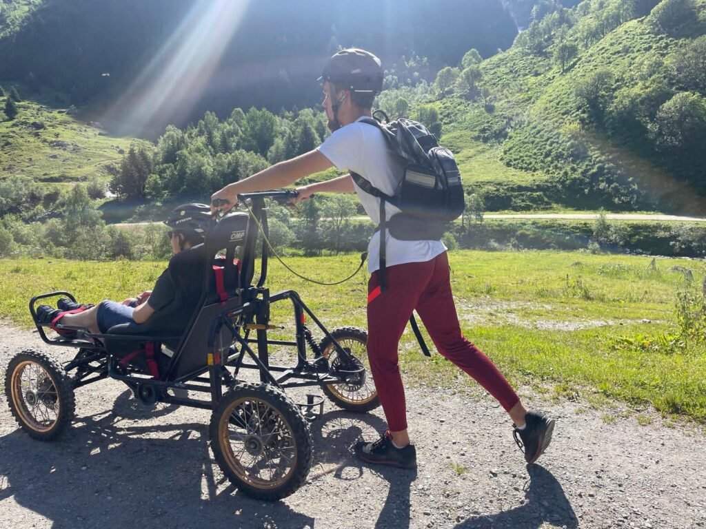 personne dans un cimgo poussée par un accompagnateur